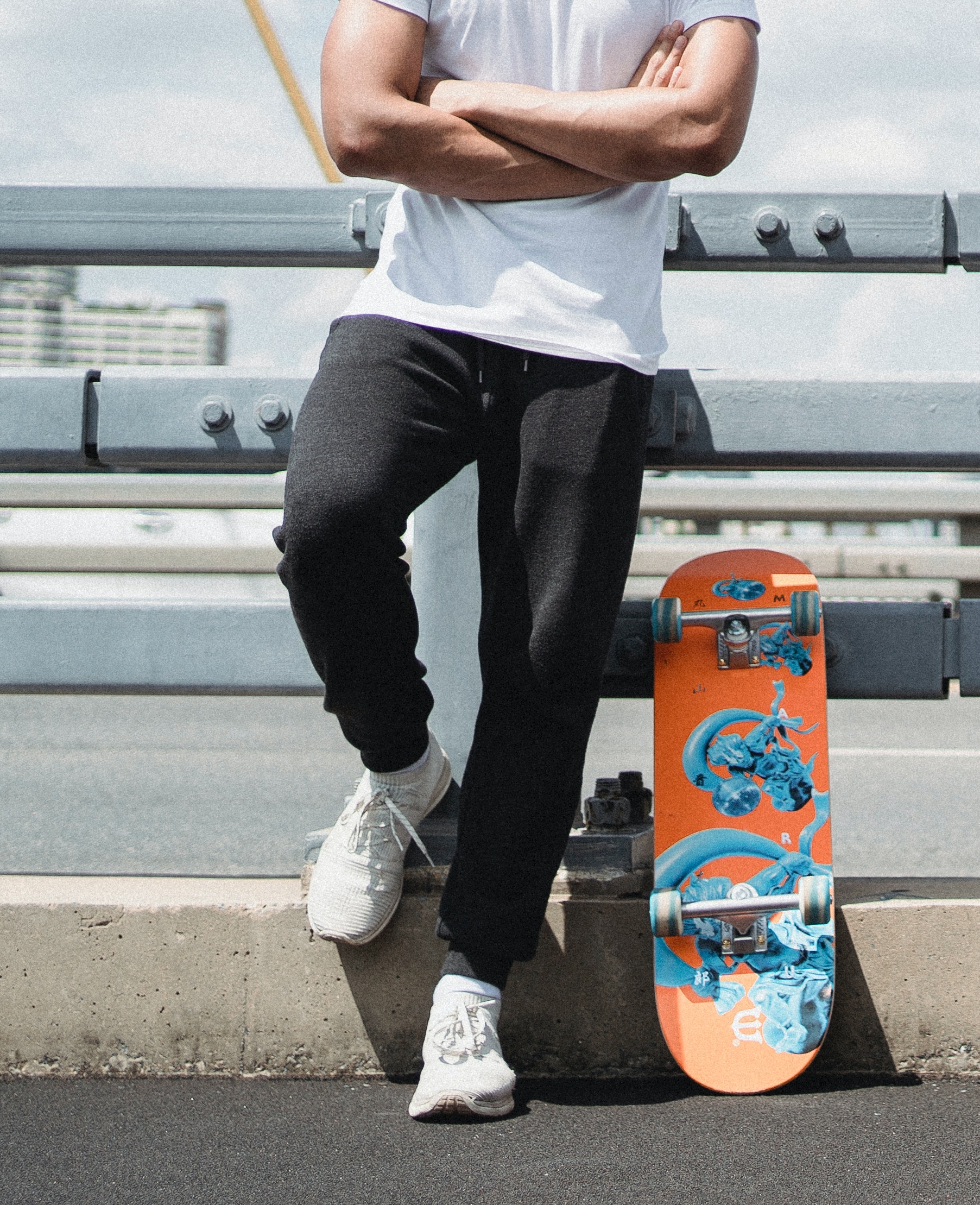 En mand står ved siden af sit skateboard
