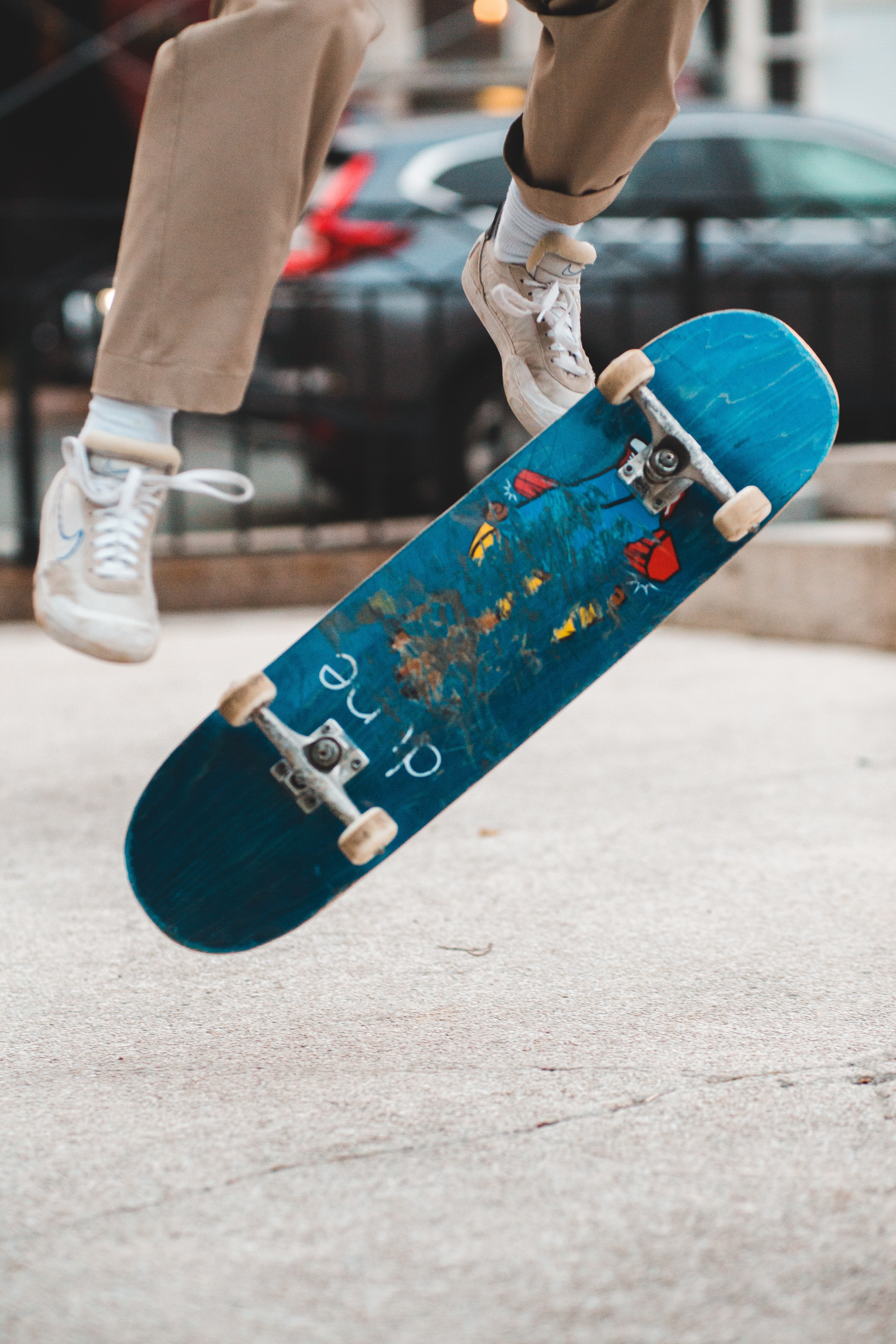 En der laver tricks på et blåt skateboard