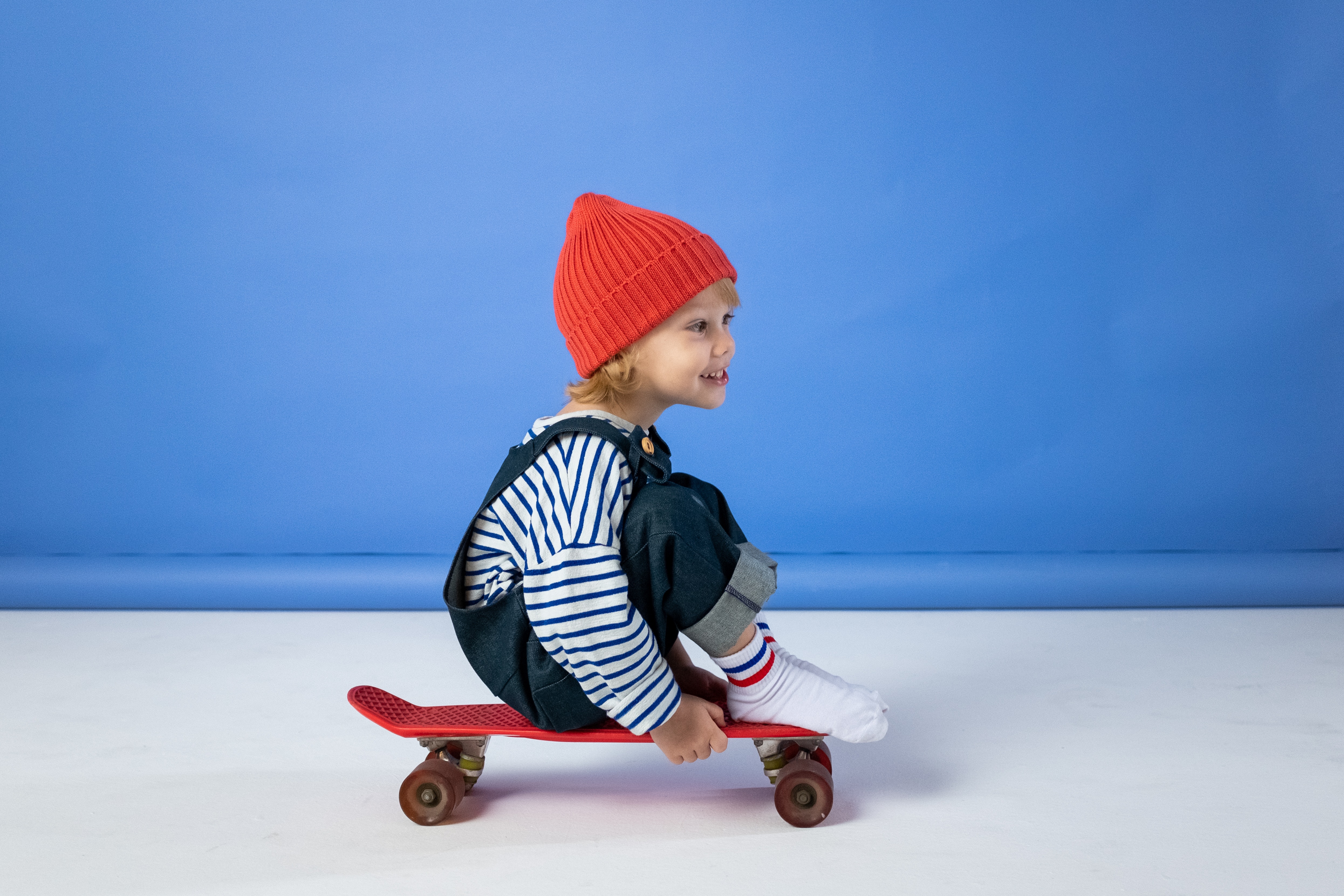 Et barn, som sidder på et rødt skateboard